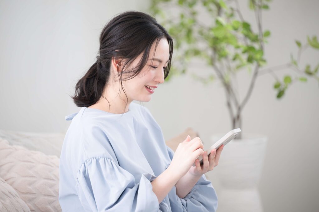 スマホで調べたことでライバー事務所に所属するメリットを知って喜ぶ女性